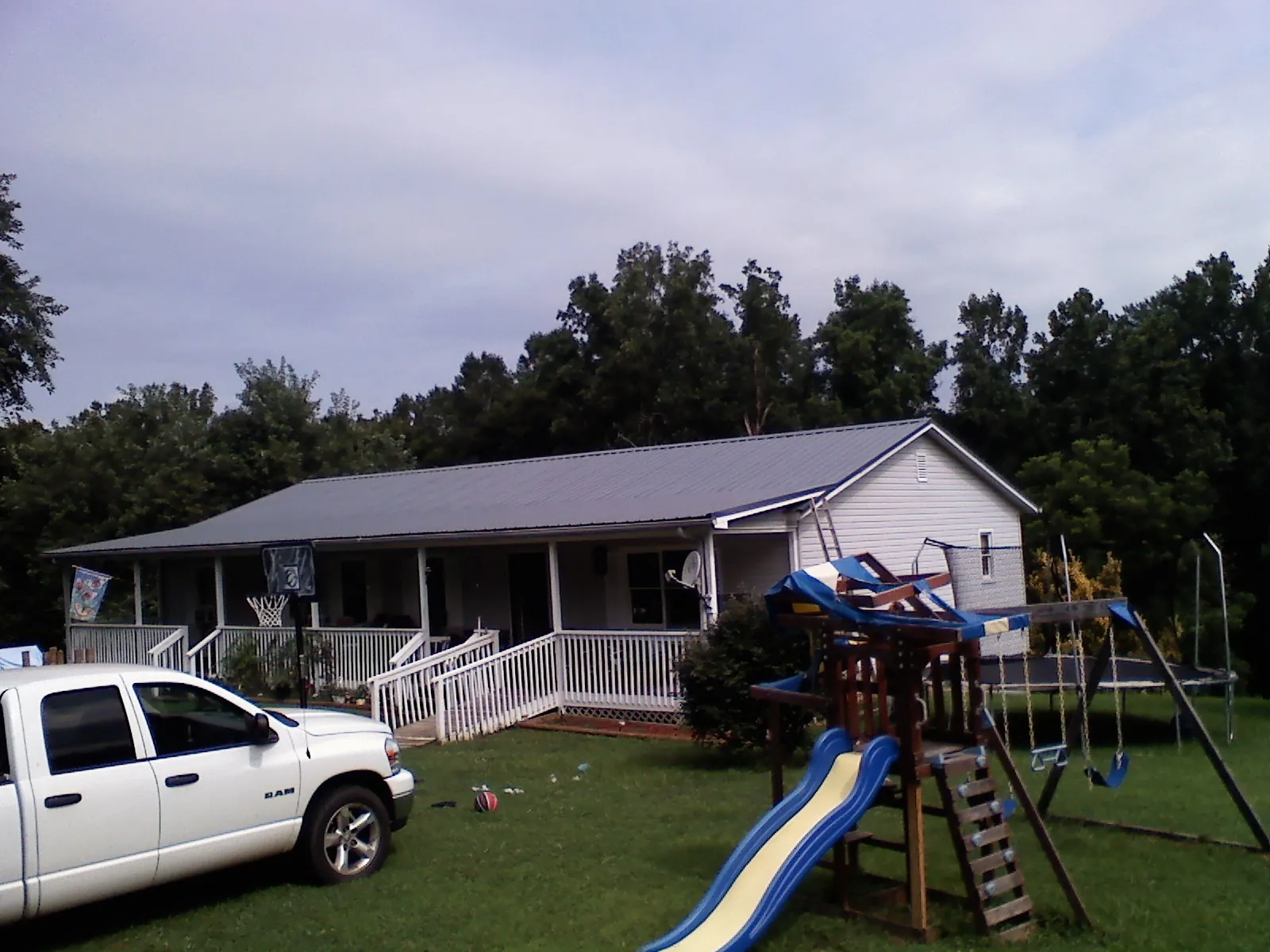 Dark metal roof on a country home with a full length front porch in Bonnieville