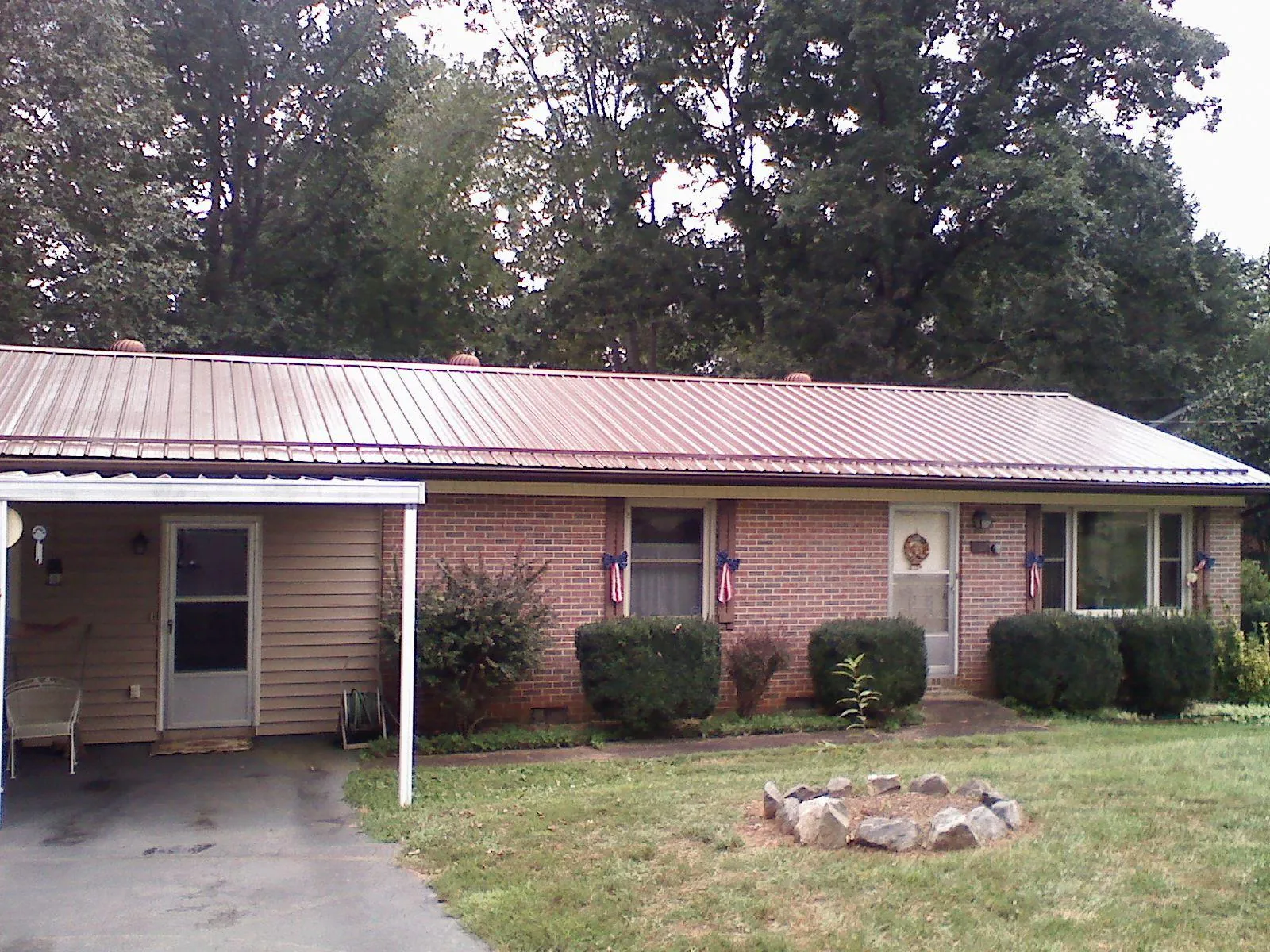 Bronze metal roof and carport on a brick ranch home — Roof Repair work by our crew in Bonnieville